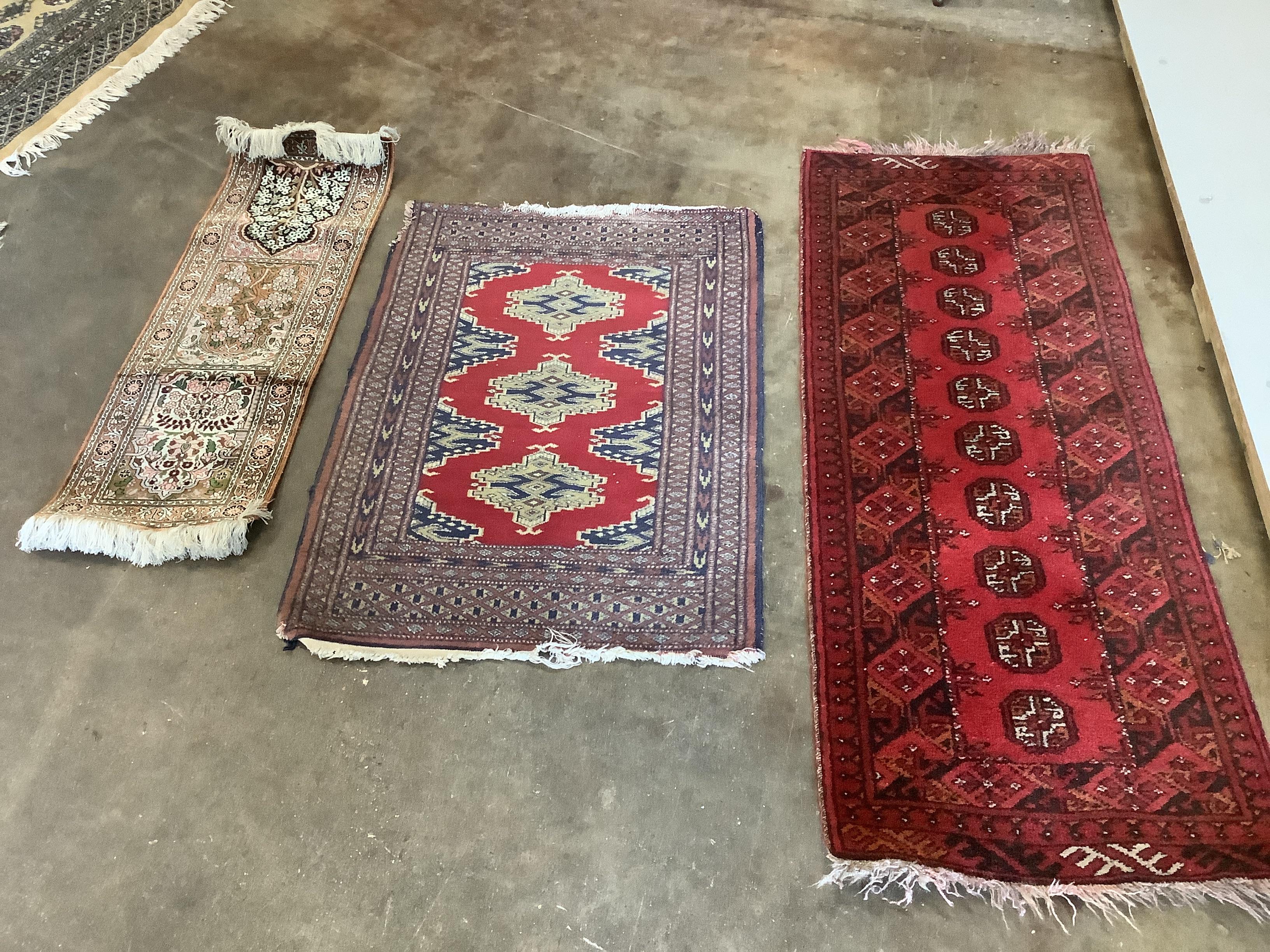 A Persian part silk mat with triple panel of flowers, 92 x 31cm and two small rugs, 93 x 62cm and 134 x 51cm